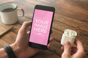 Man Holding iPhone and Earphones Mockup Generator